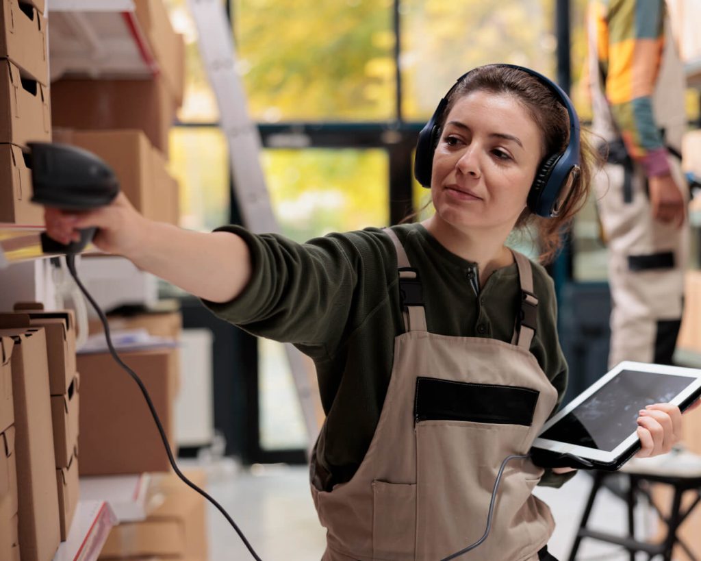 Empleado De Almacén Utilizando Un Escáner Y Una Tablet Para Automatizar El Proceso De Inventario.